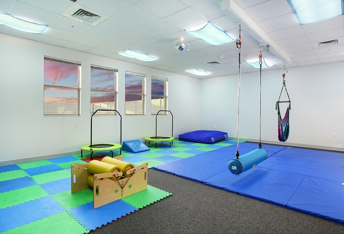 Real sensory integration room with swing, trampolines, padded mats and balance equipment